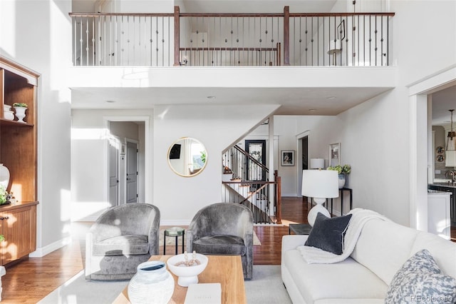 living room with a towering ceiling and light hardwood / wood-style flooring