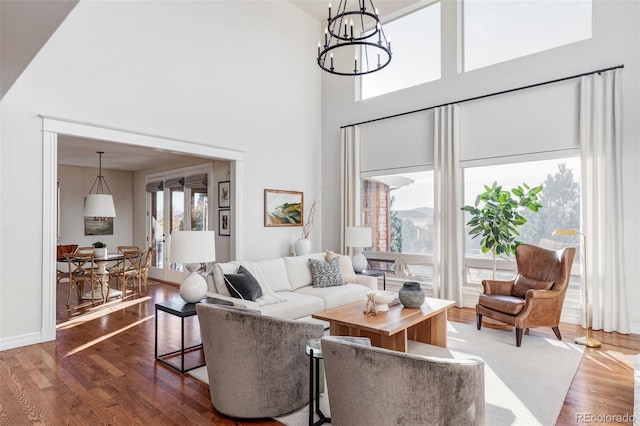 living room featuring a high ceiling, dark hardwood / wood-style flooring, and an inviting chandelier