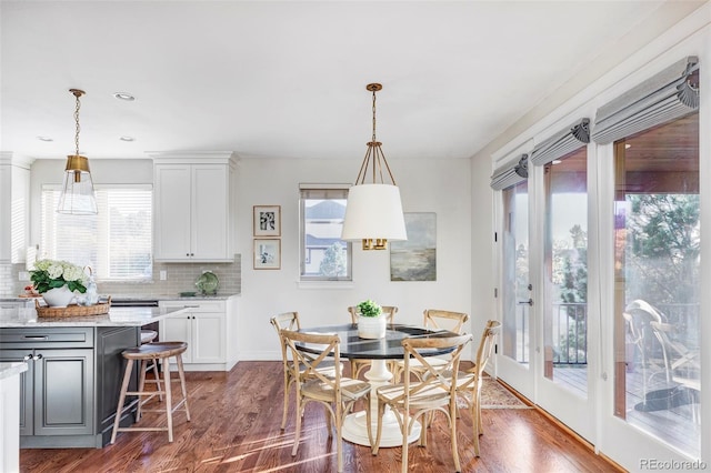 dining area featuring dark wood-type flooring and a wealth of natural light