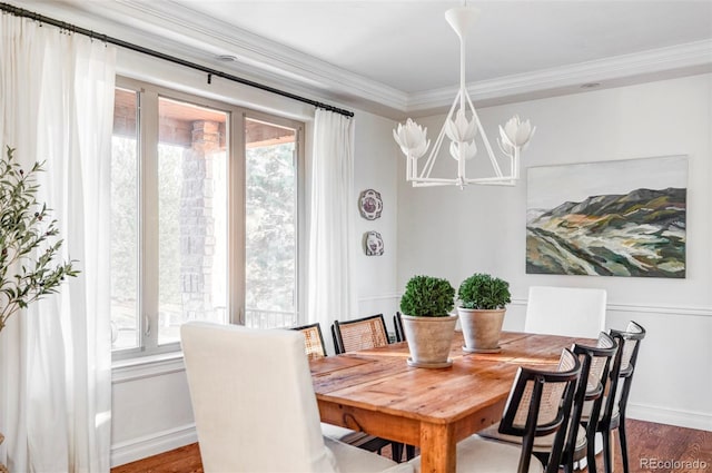 dining space featuring a wealth of natural light, wood-type flooring, a notable chandelier, and ornamental molding