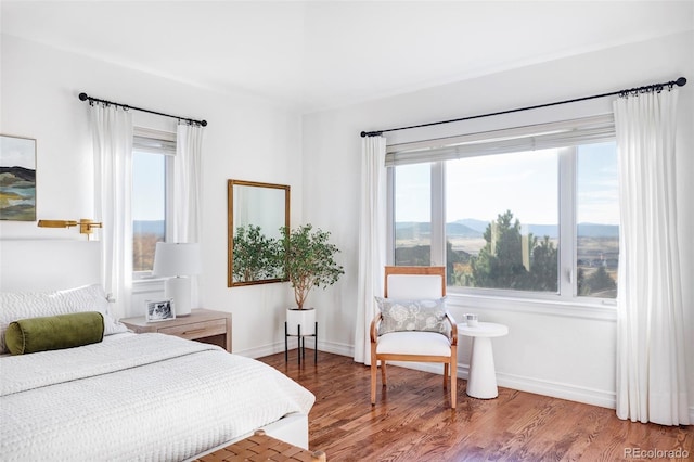 bedroom with hardwood / wood-style floors and a mountain view