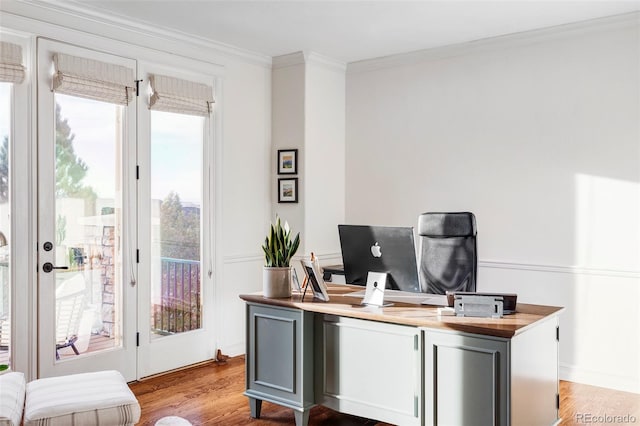 office space featuring light wood-type flooring and crown molding