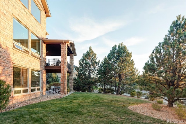 view of yard featuring a balcony and a patio area