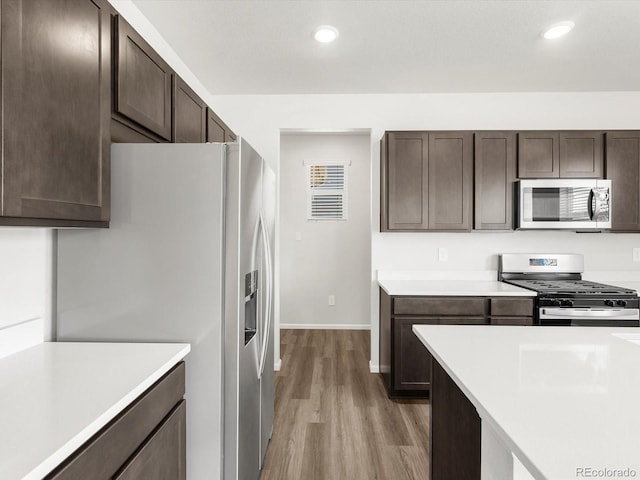 4635 Goldflower Dr, Johnstown, CO 80534 - kitchen featuring stainless steel appliances, light wood-style floors, dark brown cabinetry, light countertops, and recessed lighting