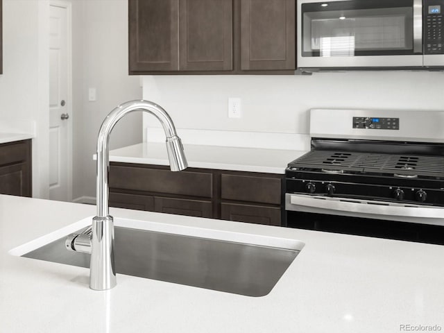 4635 Goldflower Dr, Johnstown, CO 80534 - kitchen with stainless steel appliances, dark brown cabinets, and light countertops