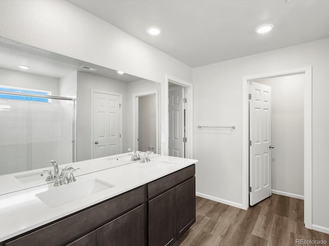 4635 Goldflower Dr, Johnstown, CO 80534 - bathroom with wood finished floors, double vanity, a tile shower, and recessed lighting
