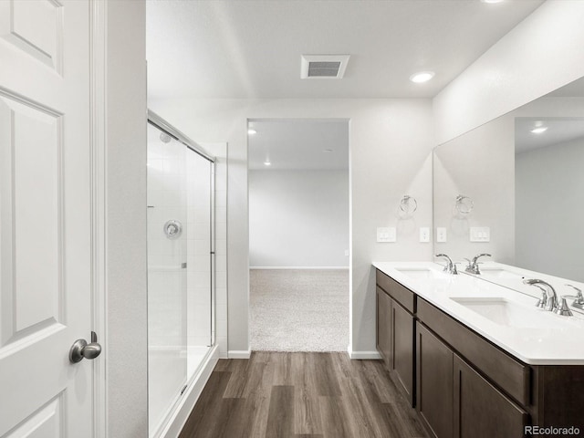 4635 Goldflower Dr, Johnstown, CO 80534 - bathroom featuring wood finished floors, a shower stall, double vanity, and recessed lighting