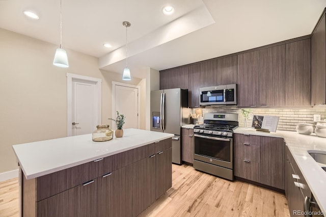 2442 S Bannock St, Denver, CO 80223 - kitchen featuring appliances with stainless steel finishes, tasteful backsplash, light wood finished floors, light countertops, and recessed lighting