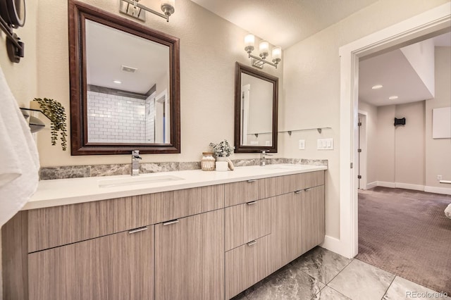 2442 S Bannock St, Denver, CO 80223 - bathroom featuring double vanity, marble look tiles, and baseboards