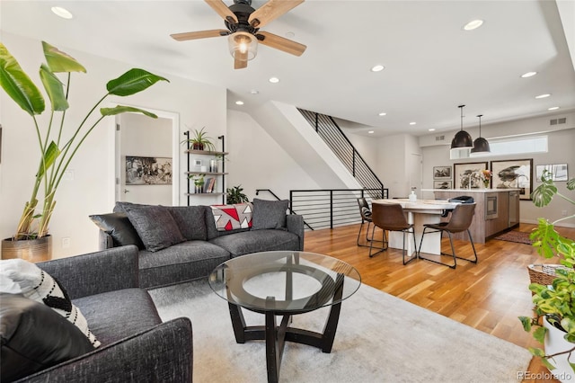 living room with light wood-style floors, recessed lighting, stairway, and a ceiling fan