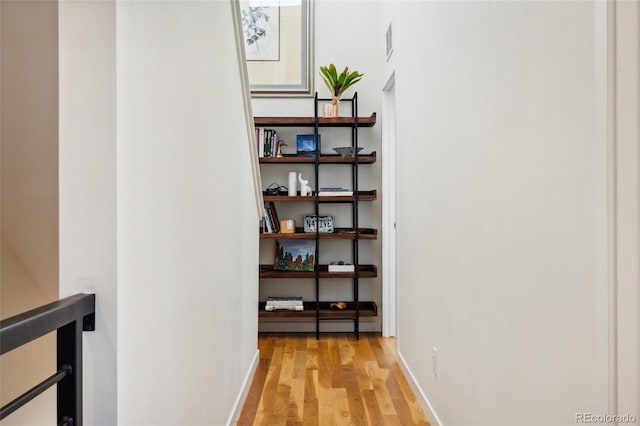 hall with light wood finished floors and baseboards