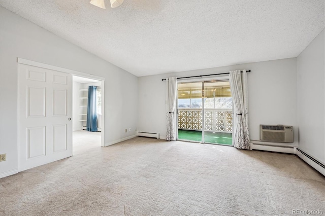 carpeted empty room with a baseboard radiator, an AC wall unit, and a textured ceiling