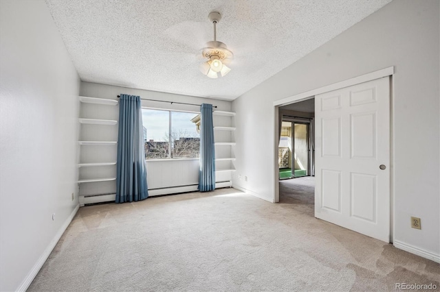 carpeted empty room with ceiling fan, a textured ceiling, and a baseboard heating unit