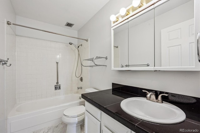 full bathroom featuring tiled shower / bath combo, vanity, and toilet