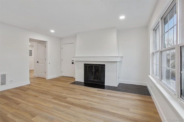 9120 E Girard Ave Unit 12, Denver, CO 80231 - unfurnished living room with a fireplace with flush hearth, wood finished floors, and recessed lighting