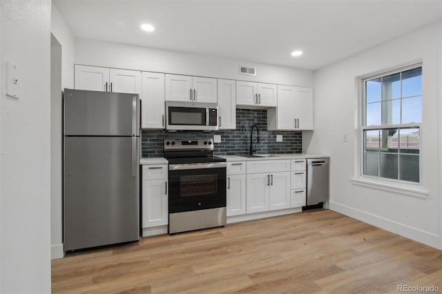 9120 E Girard Ave Unit 12, Denver, CO 80231 - kitchen with stainless steel appliances, light countertops, white cabinets, tasteful backsplash, and recessed lighting