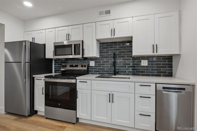 9120 E Girard Ave Unit 12, Denver, CO 80231 - kitchen featuring stainless steel appliances, light countertops, white cabinetry, and recessed lighting