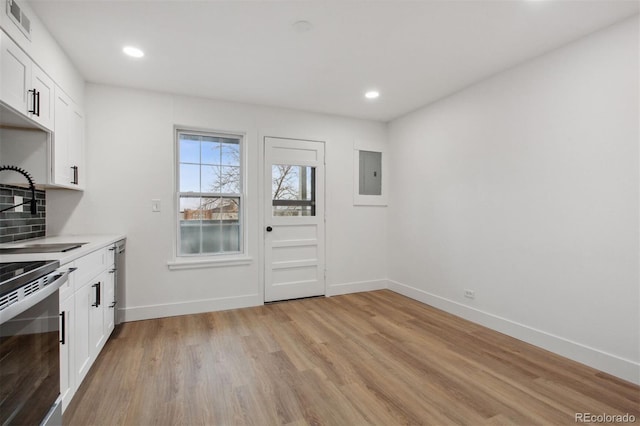 9120 E Girard Ave Unit 12, Denver, CO 80231 - kitchen featuring light wood-style flooring, white cabinets, light countertops, recessed lighting, and electric panel