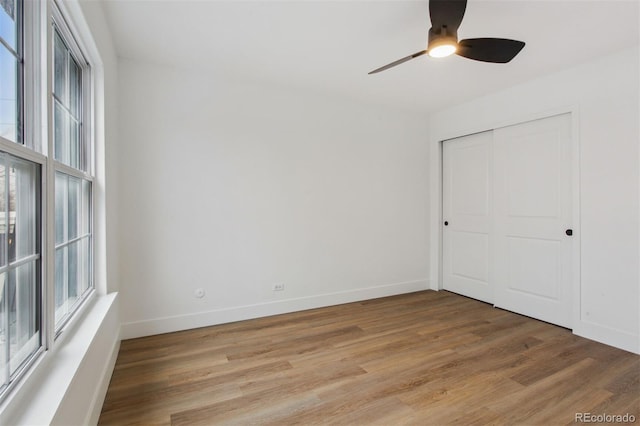 9120 E Girard Ave Unit 12, Denver, CO 80231 - unfurnished bedroom with multiple windows, light wood-type flooring, a closet, and ceiling fan