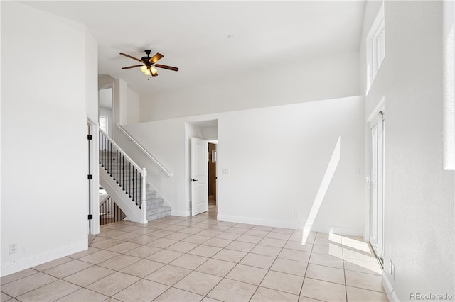 420 Sunshine Pkwy, Golden, CO 80403 - unfurnished living room with ceiling fan, light tile patterned floors, stairs, plenty of natural light, and a high ceiling