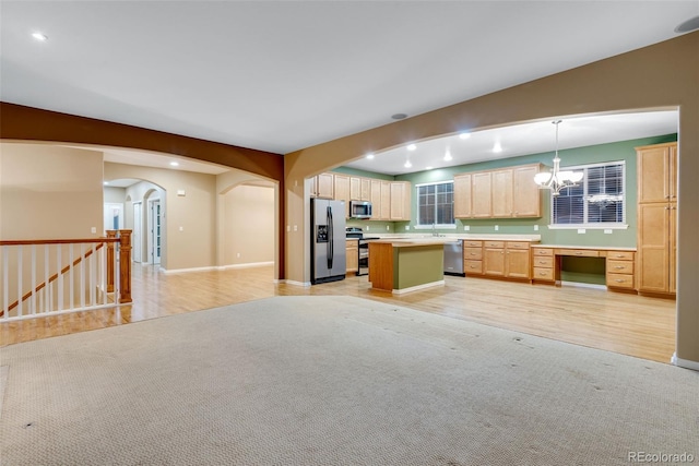 kitchen featuring hanging light fixtures, light hardwood / wood-style flooring, light brown cabinetry, a kitchen island, and stainless steel appliances