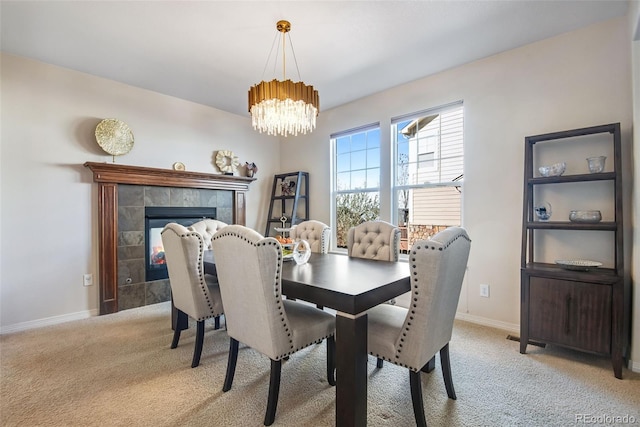 dining space with a notable chandelier, light colored carpet, visible vents, a tile fireplace, and baseboards