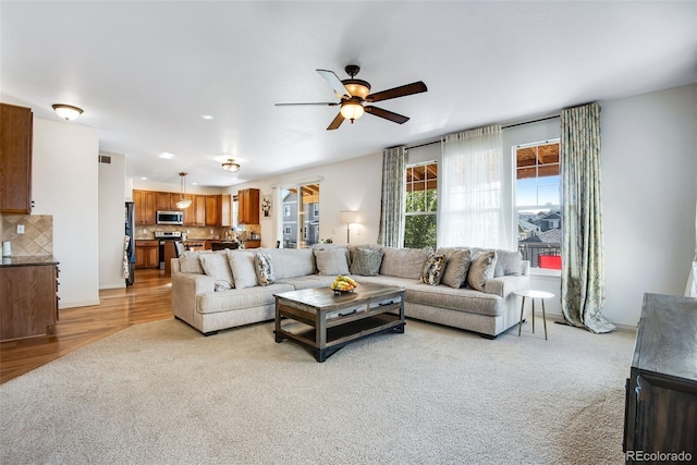 living area featuring ceiling fan and light colored carpet