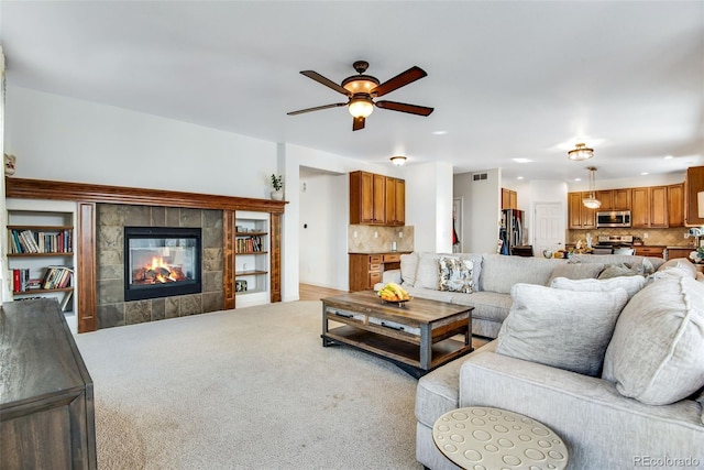 carpeted living area featuring visible vents, a tile fireplace, a ceiling fan, and recessed lighting