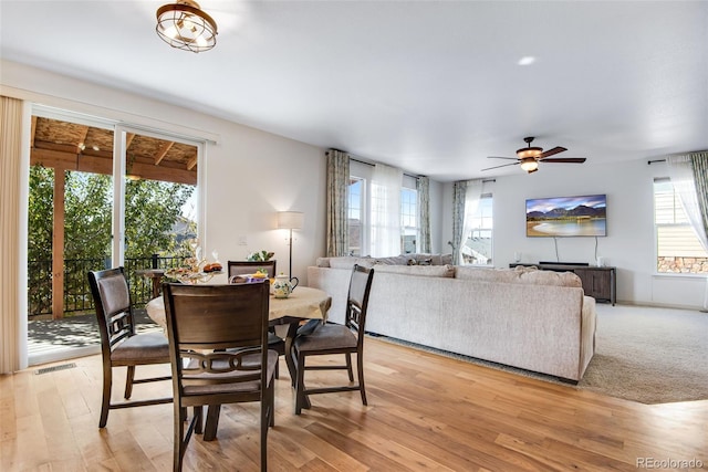 dining area with light wood finished floors, visible vents, and a ceiling fan