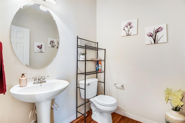 bathroom featuring baseboards, toilet, and wood finished floors