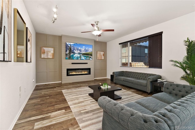 25127 E Maple Ave, Aurora, CO 80018 - living area with wood finished floors, ceiling fan, baseboards, and a large fireplace