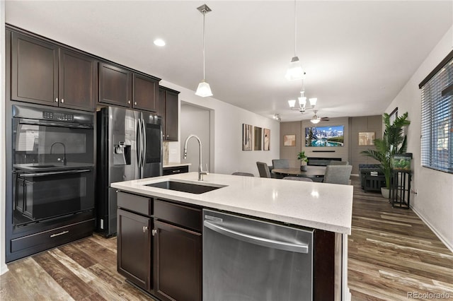 25127 E Maple Ave, Aurora, CO 80018 - kitchen featuring stainless steel appliances, a sink, a chandelier, dark brown cabinetry, and dark wood-style flooring