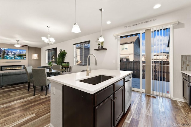 25127 E Maple Ave, Aurora, CO 80018 - kitchen with a sink, dark wood-type flooring, a glass covered fireplace, stainless steel dishwasher, and recessed lighting