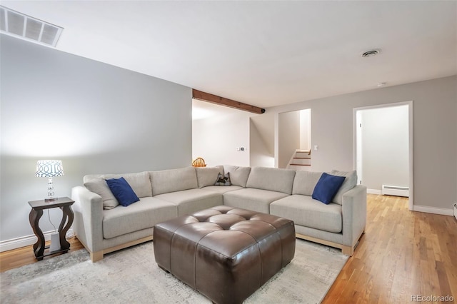 living area featuring baseboard heating, light wood-type flooring, baseboards, and stairway