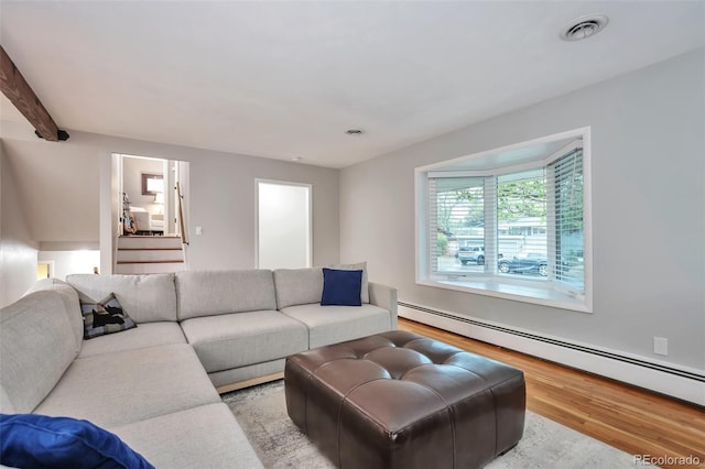living room with a baseboard heating unit and wood finished floors