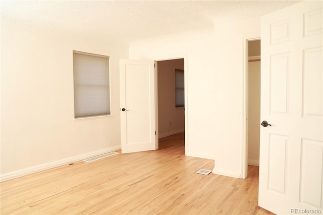 unfurnished bedroom featuring light hardwood / wood-style floors and a textured ceiling