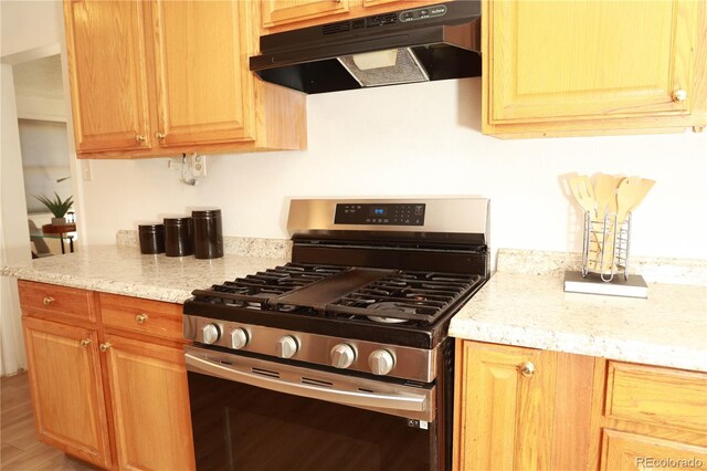 kitchen featuring light stone counters and stainless steel gas range