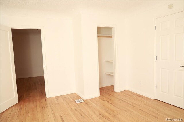 unfurnished bedroom with light hardwood / wood-style flooring and a closet