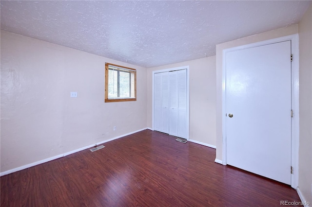 1703 W Weaver Ave, Littleton, CO 80120 - unfurnished bedroom featuring wood finished floors, a textured ceiling, a closet, and baseboards