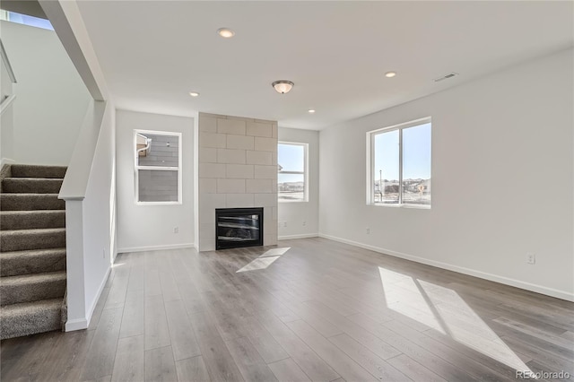 unfurnished living room featuring hardwood / wood-style flooring and a fireplace