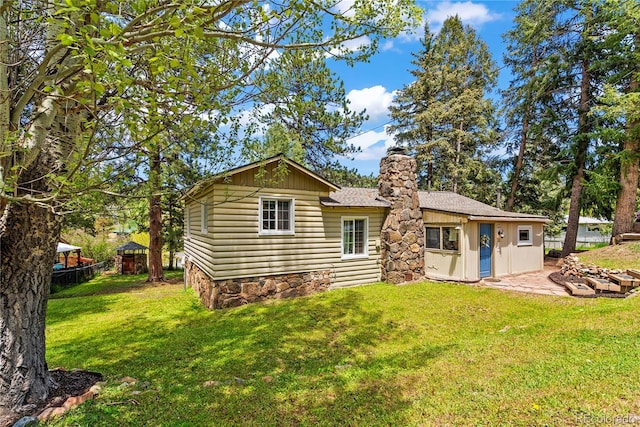26351 Sheldon St, Kittredge, CO 80457 - back of house with a chimney, a patio, and roof with shingles