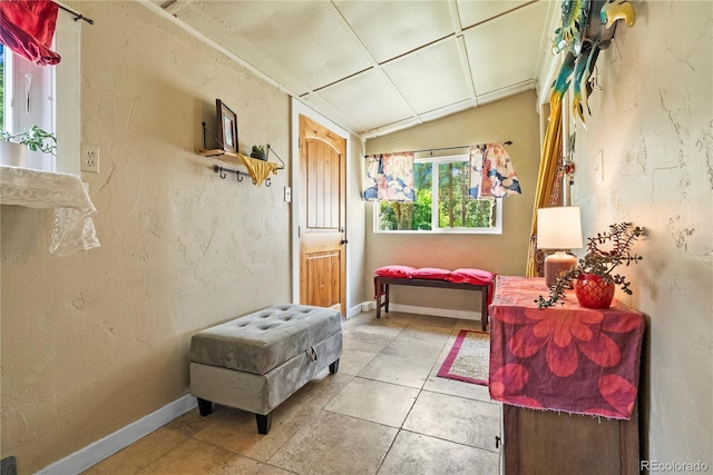 26351 Sheldon St, Kittredge, CO 80457 - corridor featuring light tile patterned flooring, vaulted ceiling, baseboards, and a textured wall