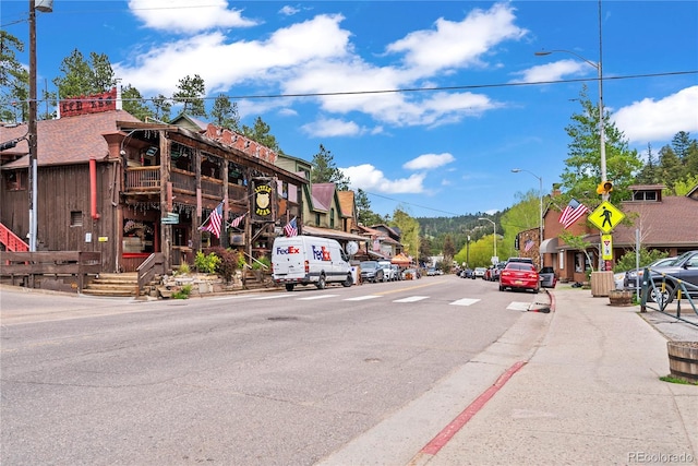 26351 Sheldon St, Kittredge, CO 80457 - view of asphalt street with street lights, sidewalks, traffic signs, and curbs