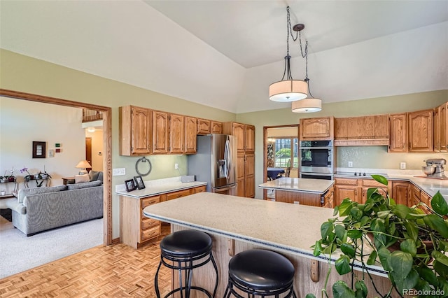 13837 W 59th Pl, Arvada, CO 80004 - kitchen with appliances with stainless steel finishes, vaulted ceiling, light countertops, a center island, and a kitchen bar