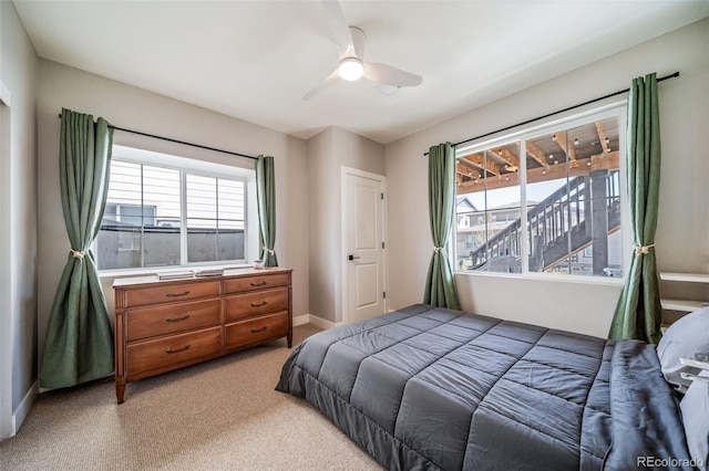 bedroom featuring a ceiling fan, baseboards, and light colored carpet