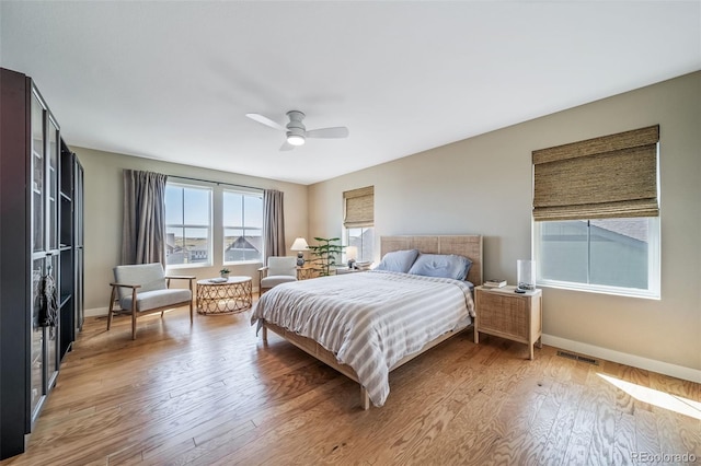 bedroom featuring ceiling fan, baseboards, visible vents, and light wood-style flooring
