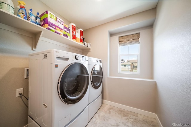 laundry room featuring washing machine and dryer, baseboards, and laundry area