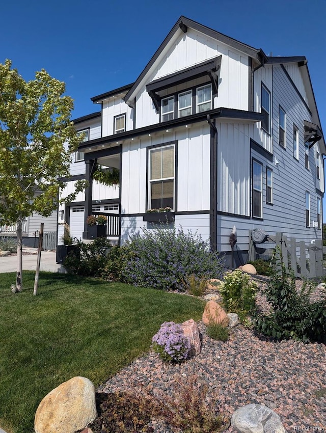 exterior space featuring board and batten siding and a front yard