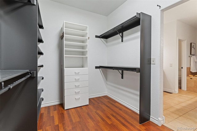 walk in closet with wood-type flooring