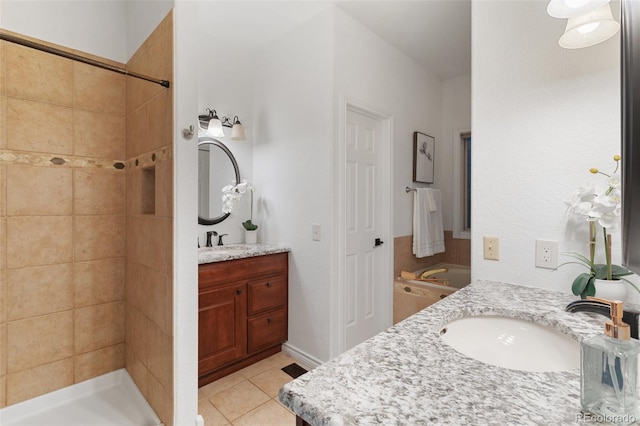 bathroom with tile patterned flooring, vanity, and a tile shower